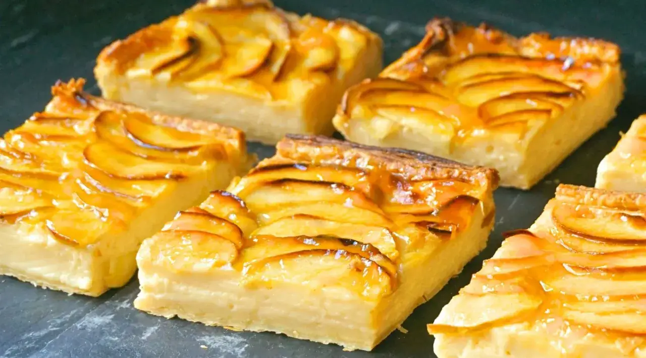 Porciones de tarta de manzana con crema pastelera, cubiertas de glaseado brillante y rodajas de manzana caramelizadas.