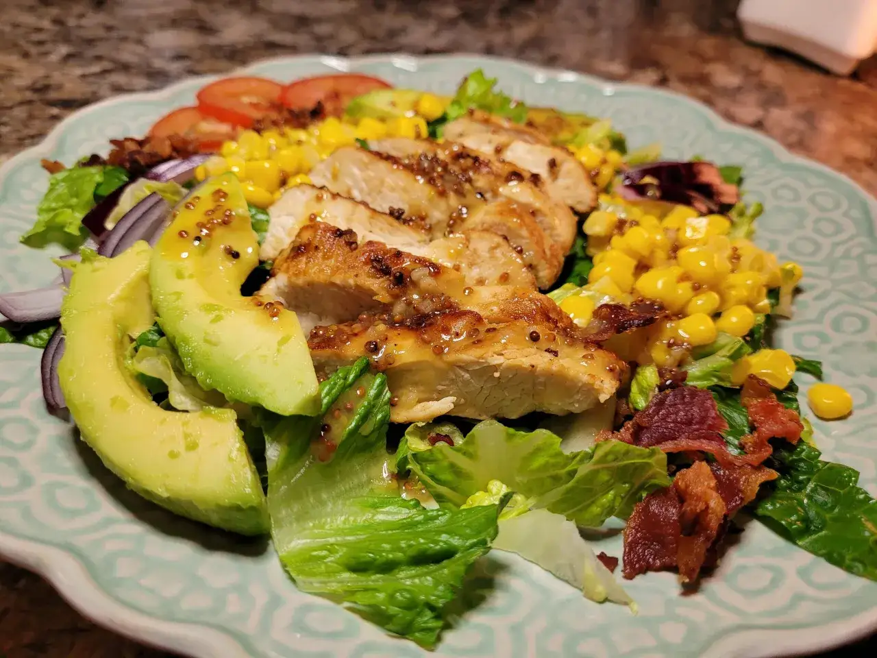 Ensalada con pollo a la parrilla, aguacate, maíz, tomate y tocino crujiente, aderezada con una deliciosa salsa miel y mostaza.