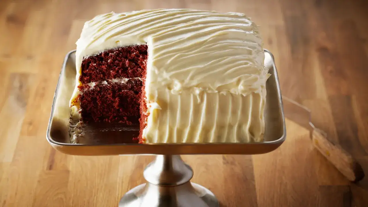 Tarta red velvet con glaseado blanco cremoso, lista para ser servida.