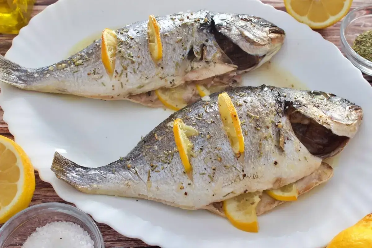 Dos doradas al horno, jugosas y perfumadas con limón y hierbas, listas para disfrutar.