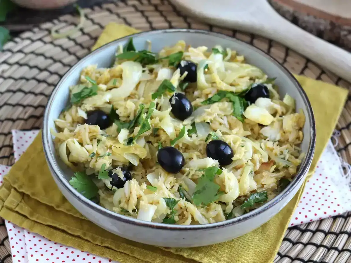 Delicioso bacalao a bras, un plato tradicional portugués con desmigado de bacalao, patatas finas, cebolla y aceitunas negras.