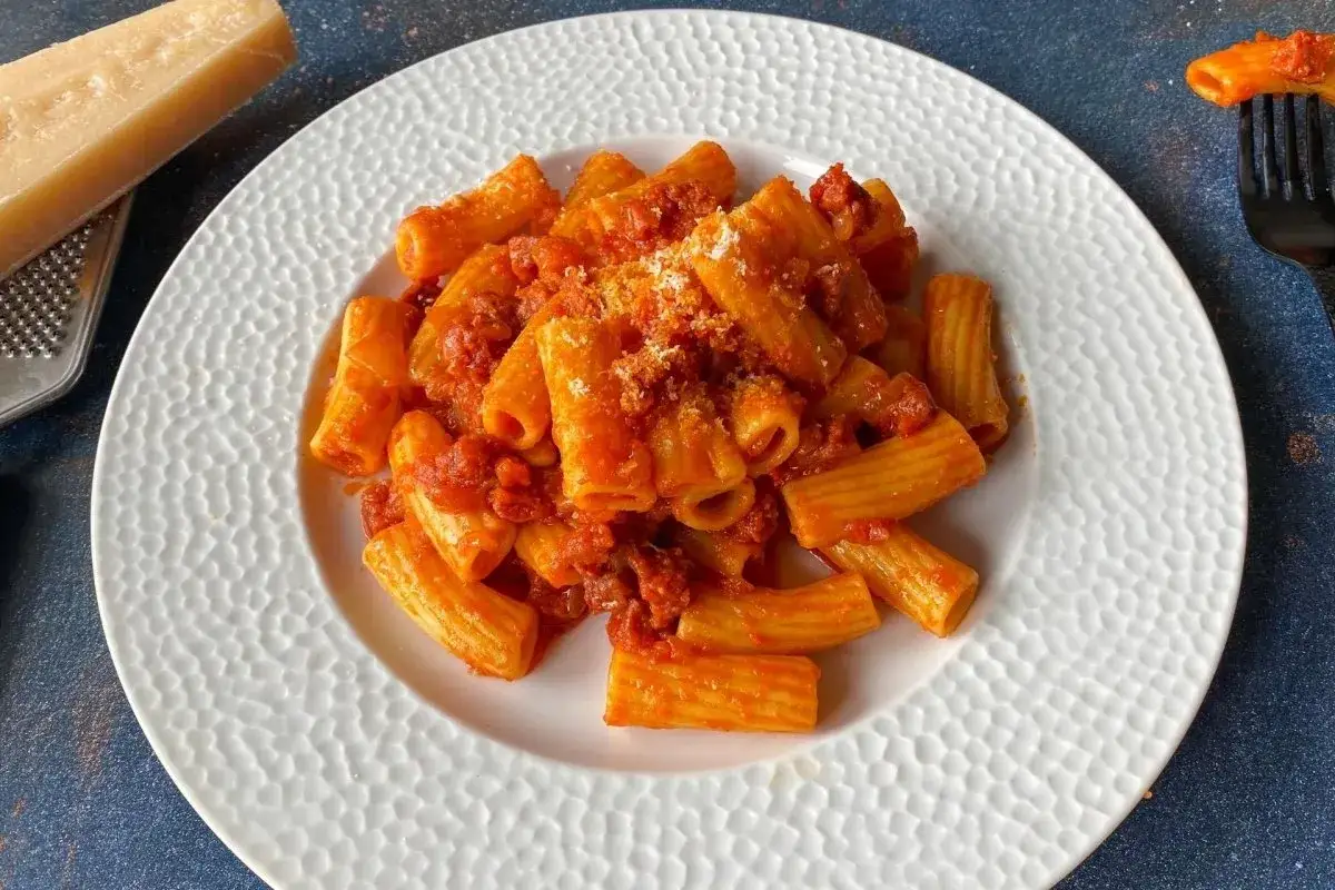 Un plato de rigatoni con una sabrosa salsa de tomate y chorizo, espolvoreado con queso rallado.