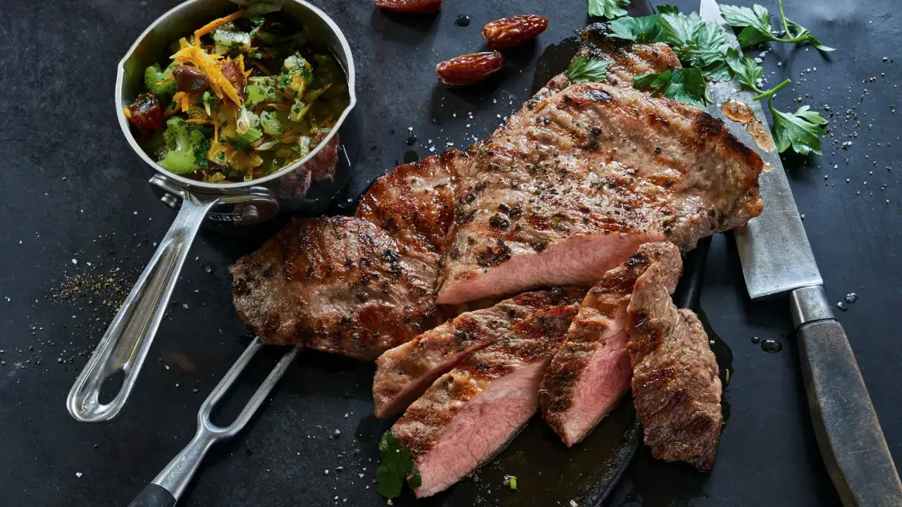 El secreto de cerdo a la parrilla, jugoso y tierno, acompa&ntilde;ado de una guarnici&oacute;n fresca y d&aacute;tiles.