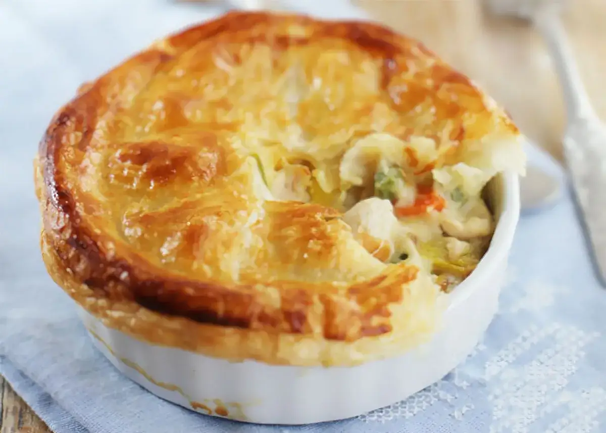 Quiche de pollo individual, con masa dorada y relleno cremoso de pollo y verduras.